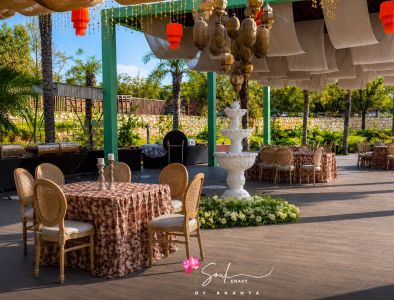 Outdoor dining table with intricate floral runner and candlesticks